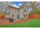 Back exterior view with fenced yard, small patio area, and neutral-colored siding at 3637 Elm St, Atlanta, GA 30354