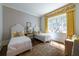 bedroom with hardwood floors, two twin beds, and a window seat with bright yellow curtains at 2440 Peachtree Nw Rd # 1, Atlanta, GA 30305
