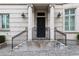 Classic front entrance with elegant columns, black door, wrought iron railings, and beautiful brick paving at 2440 Peachtree Nw Rd # 1, Atlanta, GA 30305