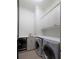 The laundry room has a washer, dryer, sink, quartz countertops, and white cabinets at 2440 Peachtree Nw Rd # 1, Atlanta, GA 30305