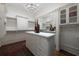 This is a walk-in closet with hardwood floors, white cabinets, island and a chandelier at 2440 Peachtree Nw Rd # 1, Atlanta, GA 30305