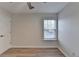 This bright bedroom includes a window, wood-style flooring, and a neutral color palette at 3550 Lakeheath Dr, Cumming, GA 30041