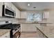 Well-lit kitchen featuring a granite countertop, stainless steel appliances and gas stove at 3550 Lakeheath Dr, Cumming, GA 30041