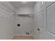 This laundry room offers wire shelving, tile flooring, and a door for easy access at 3550 Lakeheath Dr, Cumming, GA 30041