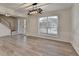 Bright living room featuring wood-look flooring, wainscoting, and a view of the staircase at 3550 Lakeheath Dr, Cumming, GA 30041