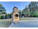 Stone outdoor fireplace on a wooden deck with a spacious backyard and wooded area at 3550 Lakeheath Dr, Cumming, GA 30041