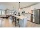 Spacious kitchen featuring stainless steel appliances, a large island with seating, and a view of the living area at 6187 Kelly Carlin Way, Norcross, GA 30071