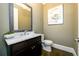 Stylish half bathroom with a decorative mirror, marble countertop, and elegant fixtures at 1110 Briar Cove Cir, Atlanta, GA 30329