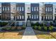 Townhome exterior with black and white facade, manicured landscaping, and front staircase at 1110 Briar Cove Cir, Atlanta, GA 30329