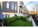 Townhome exterior featuring green turf, manicured bushes, black fences, and modern design at 1110 Briar Cove Cir, Atlanta, GA 30329