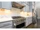 Kitchen with stainless steel appliances, gray cabinets, and a stylish backsplash at 1110 Briar Cove Cir, Atlanta, GA 30329
