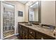 Bathroom vanity with granite countertop, dark wood cabinets, and decorative mirror at 2019 Wiltshire Pl, Snellville, GA 30078