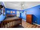 Blue bedroom with a ceiling fan, hard wood floors and a brown wood dresser at 2019 Wiltshire Pl, Snellville, GA 30078