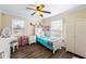 Cozy bedroom with wood floors, a ceiling fan, and natural light from the window at 2019 Wiltshire Pl, Snellville, GA 30078