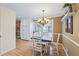 Inviting dining area with elegant chandelier, classic wainscoting, and a table set for four at 2019 Wiltshire Pl, Snellville, GA 30078