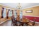 Formal dining room with a large table, elegant chandelier, and natural light from the windows at 2019 Wiltshire Pl, Snellville, GA 30078