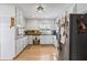 Well-lit kitchen featuring white cabinets, modern stainless steel refrigerator, and hardwood floors at 2019 Wiltshire Pl, Snellville, GA 30078