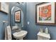 Stylish bathroom features a pedestal sink, decorative mirror, and elegant wall art at 2022 Raven Way, Atlanta, GA 30341
