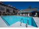 Sparkling community pool with lounge chairs, umbrellas, and a nearby building at 2022 Raven Way, Atlanta, GA 30341