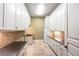 The well-lit laundry room features custom cabinetry, countertops and tiling at 2440 Peachtree Nw Rd # 22, Atlanta, GA 30305