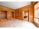 Spacious living room with wood paneling, travertine floors, and built-in bookshelves at 2440 Peachtree Nw Rd # 22, Atlanta, GA 30305