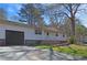 Side view of a home shows the driveway leading to the attached garage and the well-manicured lawn at 3016 Deshong Dr, Stone Mountain, GA 30087