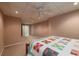 Simple basement bedroom features neutral walls, carpet, ceiling fan, and a patterned bedspread at 1030 Blankets Creek Dr, Canton, GA 30114