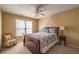 Serene bedroom with a floral patterned bed, rocking chair and soft natural light from the windows at 1030 Blankets Creek Dr, Canton, GA 30114