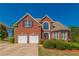 Charming two-story brick home with a manicured lawn and a two-car garage at 1030 Blankets Creek Dr, Canton, GA 30114