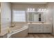 Well-lit bathroom boasts double sinks, large soaking tub, and an oversized mirror reflecting the shower at 1030 Blankets Creek Dr, Canton, GA 30114