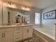 Elegant bathroom vanity with double sinks, quartz countertop, tub and modern lighting fixtures at 1800 Emory Ln # 98, Conyers, GA 30013