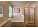 Bright bathroom featuring tub with white tile backsplash, vanity and glass-enclosed shower at 1800 Emory Ln # 98, Conyers, GA 30013