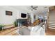 Inviting living room featuring hardwood floors, fireplace, modern ceiling fan, and easy access to the staircase and kitchen at 2384 Provence Park Way, Decatur, GA 30033