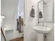 Bright powder room featuring a pedestal sink, neutral colors, and easy access to the staircase at 2384 Provence Park Way, Decatur, GA 30033