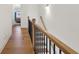 Well-lit staircase with hardwood steps, black iron balusters, and an oak handrail at 2384 Provence Park Way, Decatur, GA 30033