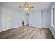 Spacious bedroom with light blue walls, modern flooring, and entrances to a bathroom at 9023 Stoneleigh Trce, Douglasville, GA 30134