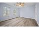 Serene bedroom with light blue walls, modern flooring, and natural light from two windows at 9023 Stoneleigh Trce, Douglasville, GA 30134