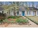 Charming townhouse with vibrant flower garden and a bright blue front door at 9023 Stoneleigh Trce, Douglasville, GA 30134