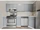 Well-lit kitchen featuring stainless steel appliances, gray cabinetry, and modern flooring at 9023 Stoneleigh Trce, Douglasville, GA 30134