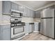 Functional kitchen featuring gray cabinets, stainless steel appliances, and wood-look flooring at 9023 Stoneleigh Trce, Douglasville, GA 30134