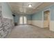 Spacious carpeted basement with stone accent wall, wainscotting, and French doors at 189 Meadow Spring Dr, Temple, GA 30179