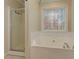 Bright bathroom featuring a soaking tub under a window with view of trees outside at 189 Meadow Spring Dr, Temple, GA 30179