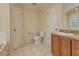 Neutral bathroom features a toilet, tub, and single sink vanity with a view from the window at 189 Meadow Spring Dr, Temple, GA 30179