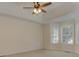 Main bedroom featuring a tray ceiling, ceiling fan and bright windows at 189 Meadow Spring Dr, Temple, GA 30179