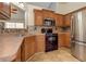 Kitchen with black appliances, wood cabinets and stylish mosaic tile backsplash at 189 Meadow Spring Dr, Temple, GA 30179