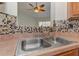 Kitchen sink and tile backsplash with a ceiling fan visible through the window at 189 Meadow Spring Dr, Temple, GA 30179