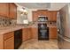 Kitchen with black appliances, wood cabinets and stylish mosaic tile backsplash at 189 Meadow Spring Dr, Temple, GA 30179