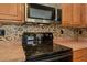 Close-up of the black range oven and stainless steel microwave in the kitchen at 189 Meadow Spring Dr, Temple, GA 30179