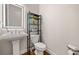 Modern bathroom featuring a pedestal sink, stylish toilet, and decorative shelving unit at 1949 Skyfall Cir, Brookhaven, GA 30319