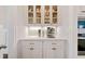 Elegant coffee bar featuring white cabinets, quartz countertop, display cabinets, and stainless steel coffee machine at 1949 Skyfall Cir, Brookhaven, GA 30319